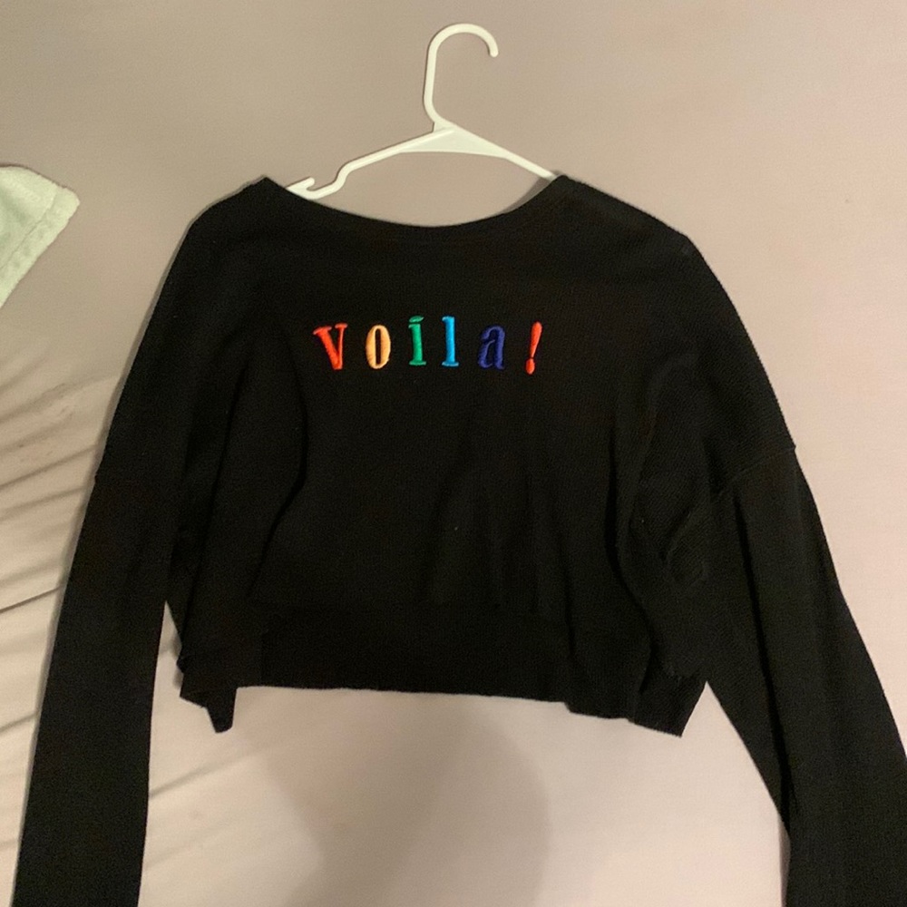 An XS long sleeve crop top, with “VOILA!” embroidered on the from in rainbow.